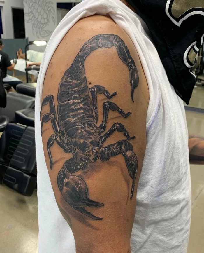 Black and grey super realistic scorpion upper shoulder and bicep tattoo by tattoo artist Russ Howie of Sacred Mandala Studio in Durham, NC.